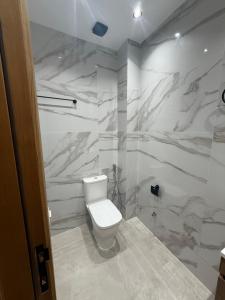 a white bathroom with a toilet and a shower at اقامة هبة 3 in Yebha