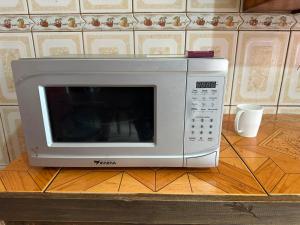 a microwave oven sitting on top of a table at Céntrico con cocina parqueadero e internet in Baños