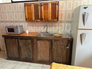 a kitchen with a sink and a microwave at Céntrico con cocina parqueadero e internet in Baños