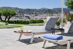 two lounge chairs and a table on a patio at Skopelos Village Hotel in Skopelos Town