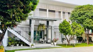 a white building with a staircase in front of it at The Viera Chiangrai in Chiang Rai