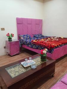 a bedroom with a bed and a table with a tray at New aalbayan hotel in Lahore