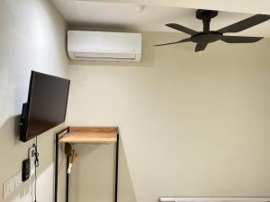 a room with a ceiling fan and a television at Apex Hotel by Setapak Central in Kuala Lumpur