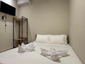 a white bed with two white flowers on it at Apex Hotel by Setapak Central in Kuala Lumpur +20 photos