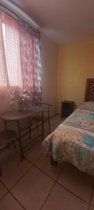 a bedroom with a bed and a table and window at HabitacionSUPER4 2 personas Casa SFco in Zacatlán
