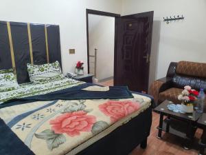 a bedroom with two beds and a table with flowers at New aalbayan hotel in Lahore