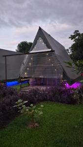 a large building with a black roof with lights at Flora Glamping de Abuela in Fortuna
