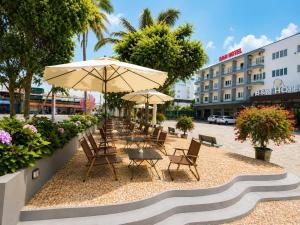 a group of chairs and tables with umbrellas at B&N HOTEL Hải Tiến in Mỹ Ðuc