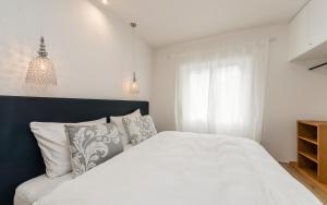 Un dormitorio con una cama blanca y una ventana. en M-Loft merangardenvilla, en Merano 38 fotos más