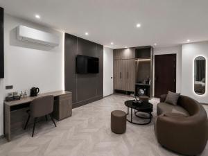 a living room with a couch and a table and a tv at B&N HOTEL Hải Tiến in Mỹ Ðuc