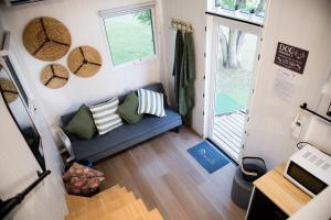 a small living room with a blue couch in a tiny house at Tiny Inja 1 by Tiny Away in Comleroy