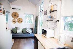 a small kitchen with a blue couch in a tiny house at Tiny Inja 1 by Tiny Away in Comleroy