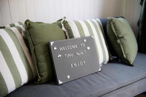 a sign sitting on top of a couch with pillows at Tiny Inja 1 by Tiny Away in Comleroy +18 photos
