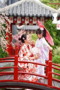 two young girls in kimonos on a roller coaster at Lotus Hotel Vuon Vua Phu Tho in Phú Thọ