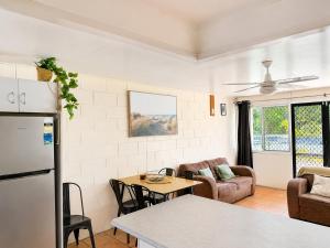 a kitchen and living room with a refrigerator and a table at Pippies Beachhouse Backpackers in Rainbow Beach