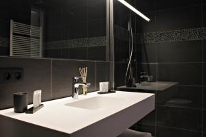 ein Badezimmer mit einem weißen Waschbecken und einem Spiegel in der Unterkunft B&B VIENNA in Lokeren