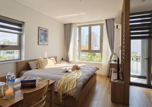 a bedroom with a bed and a table and a couch at Seaflow Staycation in Danang