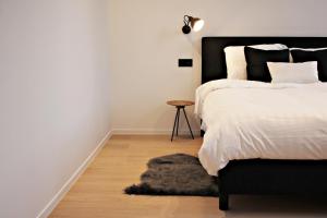 ロケレンにあるB&B VIENNAのベッドルーム1室(黒いヘッドボードとテーブル付きのベッド1台付)