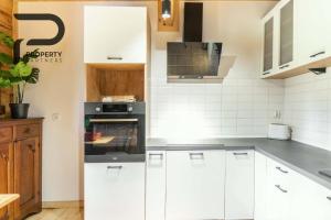 a kitchen with white cabinets and an oven at Góralski relaks in Dzianisz