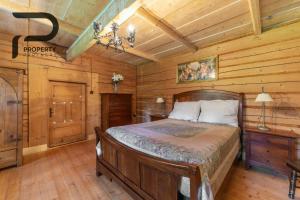 a bedroom with a bed in a room with wooden walls at Góralski relaks in Dzianisz