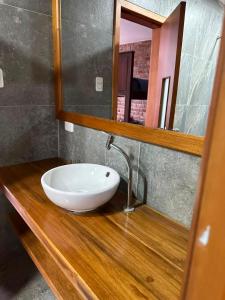 a bathroom with a sink and a mirror at Céntrico con cocina parqueadero e internet in Baños +20 photos
