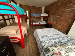 a room with two bunk beds and a brick wall at Céntrico con cocina parqueadero e internet in Baños