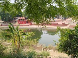 a red train is parked next to a body of water at Traveller Guest House in Varanasi