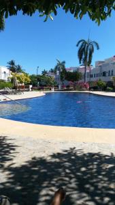 Mayan Vidanta Villas GOLF a 800 mt de la playa في أكابولكو: مسبح كبير بالنخيل والمباني