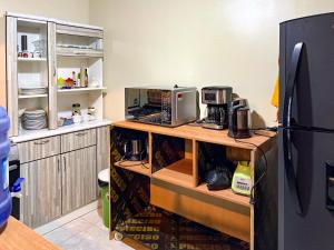 a kitchen with a counter with a microwave and a refrigerator at Hospedaje Josué Paracas in Paracas