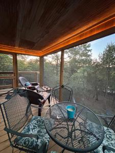 a screened in porch with a glass table and chairs at Camptown Cabin in Eagle Rock