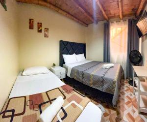a bedroom with two beds and a table in it at Hospedaje Josué Paracas in Paracas