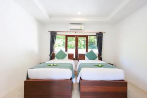 two beds in a room with a window at EASY TIME VILLA by MARALEINA in Koh Samui