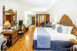 a hotel room with a large bed and a desk at Grand Excelsior Hotel - Bur Dubai in Dubai