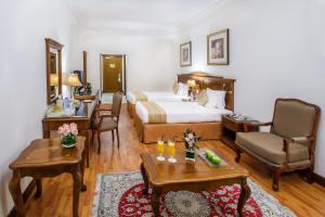 a hotel room with a bed and a living room at Grand Excelsior Hotel - Bur Dubai in Dubai
