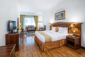 a hotel room with a bed and a television at Grand Excelsior Hotel - Bur Dubai in Dubai