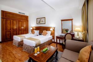 a hotel room with two beds and a table at Grand Excelsior Hotel - Bur Dubai in Dubai