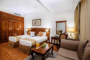 a hotel room with two beds and a table at Grand Excelsior Hotel - Bur Dubai in Dubai