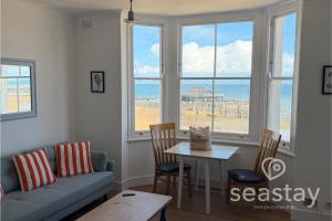 a living room with a couch and a table with chairs at Beach Lookout Direct Access to Viking Bay Sleeps 4 in Kent