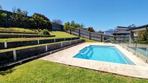 a swimming pool in the backyard of a house at Tea Tree Poolside Escape in Inverloch
