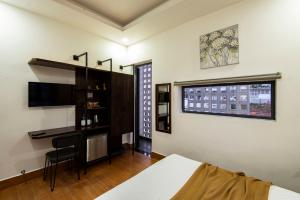 a bedroom with a bed and a desk and a window at The Node Homestay & Apartment in Xuan An