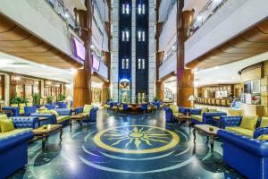 a lobby with blue chairs and tables in a building at Grand Excelsior Hotel - Bur Dubai in Dubai