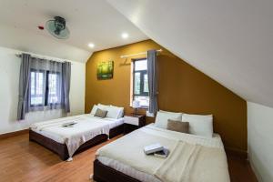 a bedroom with two beds and a window at The Node Homestay & Apartment in Xuan An