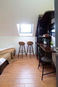 a bedroom with a bed and a desk and two stools at The Node Homestay & Apartment in Xuan An