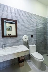 a bathroom with a toilet and a sink and a mirror at The Node Homestay & Apartment in Xuan An +46 photos