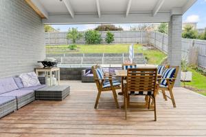 a patio with a table and chairs and a couch at Tea Tree Poolside Escape in Inverloch