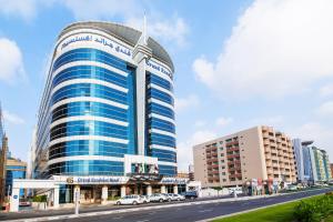 a tall building with cars parked in front of a street at Grand Excelsior Hotel - Bur Dubai in Dubai