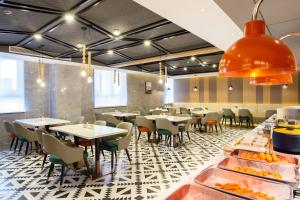 a restaurant with tables and chairs and a buffet at 库尔勒孔雀河景观带滨河西路亚朵酒店 in Korla