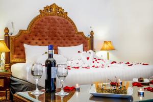 a bedroom with a bed with a bottle of wine and wine glasses at Grand Excelsior Hotel - Bur Dubai in Dubai