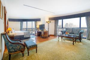 a hotel room with a bed and a living room at Grand Excelsior Hotel - Bur Dubai in Dubai