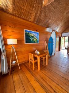 a room with a wooden wall with a table and a surfboard at Ombak Biru Resort in Tua Pejat
